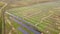 Aerial view of solar power plant under construction on green field. Assembling of electric panels for producing clean