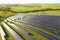 Aerial view of solar power plant under construction on green field. Assembling of electric panels for producing clean ecologic