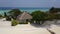 Aerial view of spa bungalow on tropical island resort hotel with white sand beach, palm trees and turquoise Indian ocean