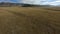 Aerial view speed flying over amazing endless dry yellow autumn meadow mountain valley