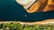 Aerial view of a speedboat sailing along the river on the shore of golden sand