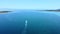 Aerial view of speedboat sailing on blue turquoise sea. Speedboat sailing towards narrow passage between island and coast