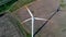 Aerial view on spinning blades of wind turbine tower on wheat field