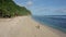 Aerial view sportsman runs alone on sandy beach, ocean, mountains on background