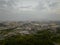 Aerial view of sprawling city on edge of green hills at dawn