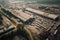 Aerial view of a sprawling factory complex with multiple buildings and delivery trucks