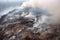 aerial view of sprawling landfill, with smoke and steam rising from the trash