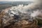 aerial view of sprawling landfill, with smoke and steam rising from the trash