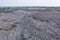 Aerial view of stack of different types of large mountain garbage pile, plastic bags, and trash with a tractor car in industrial