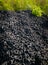 Aerial view of the stark contrast between a massive landfill of used car tires and the surrounding green trees. Tire