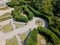 Aerial view of a statue and a flowering garden with flowerbeds and vases