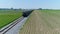 Aerial View of a Steam Engine Puffing Smoke and Steam with Passenger Coaches With a Drone Approaching the Back