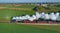 Aerial View of Steam Passenger Train Puffing Smoke in an Early Morning