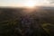 Aerial view of stone town Civita di Bagnoregio with the sun at the sunrise with clay badlands and trees in background