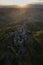 Aerial view of stone town Civita di Bagnoregio with the sun at the sunrise with clay badlands and trees in background