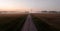 Aerial view of a straight country road and vast farmland on a foggy day