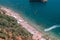 Aerial view of the strip of the summer beach, many people, kayaks, stones in the sea