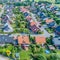 Aerial view of a suburb with detached houses, semi-detached houses and terraced houses with small front gardens and green lawns i