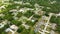 Aerial view of suburban landscape with private homes between green palm trees in Florida quiet residential area