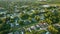 Aerial view of suburban landscape with private homes between green palm trees in Florida quiet residential area