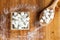 Aerial View of Sugar Cubes in Square Shaped Bowl and Spoon with Unrefined Sugar spill over in Wooden Background.