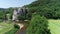 Aerial view of summer activities. People jumping into the water from high rock/cliff and group of kayakers paddling down. Green sc