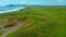 Aerial view of summer green meadows and mountains at the edge of the sea on the Isle of Skye, Scotland. Clip. Concept of