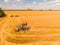 Aerial view of summer harvest. Combine harvester harvesting large field