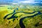 Aerial view on summer river. River stream on green meadow. Summer nature landscape. Drone view on riverside