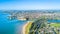 Aerial view on sunny beach with residential suburb on the background. Auckland, New Zealand.