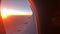 Aerial view of sunrise through airliner window in the morning. Aerial view of Cloudscape in dawn through plane window