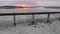 Aerial view of sunrise over frozen river or lake with steel train track concrete bridge