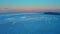 Aerial view of sunset over the frozen winter sea. Drone descends above ocean on sunrise. Flight over melting ice drift
