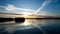 Aerial view of a sunset over the lake with clouds made by planes