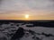 Aerial view of the sunset on a winter freezing evening. Beautiful picturesque landscape of snowy forest and field
