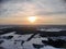 Aerial view of the sunset on a winter freezing evening. Beautiful picturesque landscape of snowy forest and field