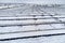 Aerial view of sustainable electrical power plant with solar photovoltaic panels covered with snow in winter for