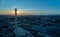 Aerial view of tall chimney of thermal power plant against setting sun.