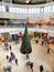 Aerial view of tall fir tree inside German central mall in Khel with customers and kids near the Christmas Decorated