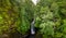 Aerial view of a tall waterfall in a narrow canyon surrounded by trees Sgwd Einion Gam, Wales, UK