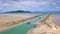 Aerial view of Thai traditional longtail boat sailing through waterway channel made in sand beach