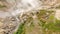 Aerial View. Thermal spring gushes out of the ground. Hot spring water in the mountains