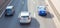 Aerial view of three cars on a three-lane road on a summer day