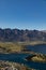 Aerial view of three paragliders over Queenstown, New Zealand with Lake Wakatipu under a blue sky