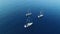 Aerial view of three white yachts or sailboats sailing together