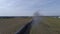Aerial view thru smoke of a restored steam locomotive and passenger cars traveling blowing smoke and steam