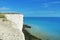 Aerial view to blue turquoise water of English channel and a little white sailboat at the background and white chalk stones of cli