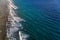 Aerial view to ocean surf at coral island