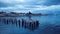 Aerial View to the Sitting Birds on the Old Wooden Pier under the Blue Sunset Sky in Puerto Natales,