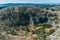 Aerial view to swamped quarry with high dry grass, small pond, rock, Czech republic